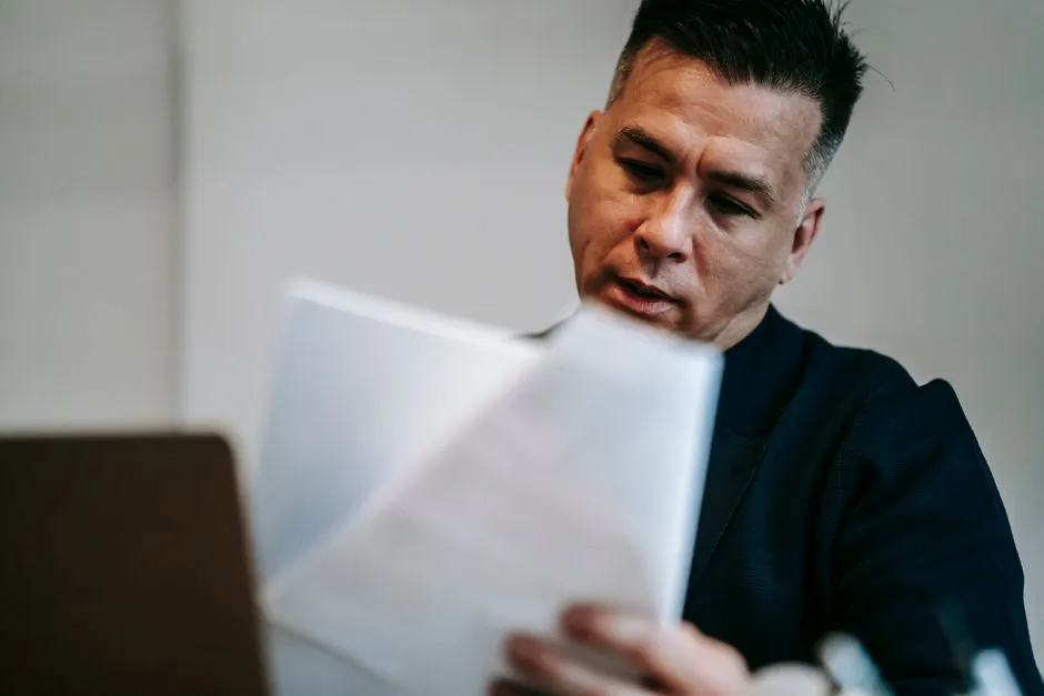 Person reviewing printed documents at a desk, illustrative photo